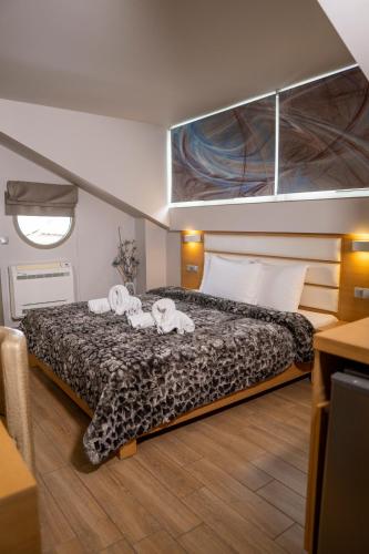 a bedroom with a bed with three towels on it at Hotel Epavlis Eleftheriadi in Paralia Katerinis