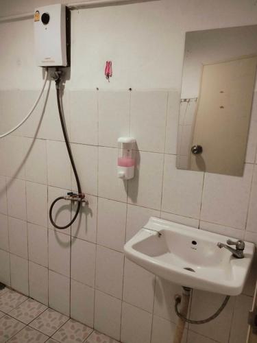 a bathroom with a sink and a mirror on the wall at ณชนกรีสอร์ท in Ban Maha Chai