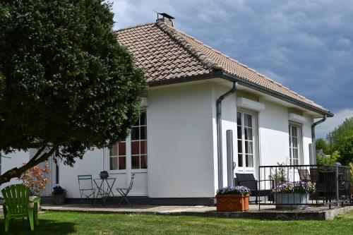 a white cottage with a tree and a lawn at gite de tounette in Authieule