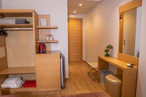a room with a bed and a desk in a room at Hotel Epavlis Eleftheriadi in Paralia Katerinis