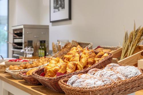 a buffet with baskets of pastries and other pastries at Aparthotel Bcn Montjuic in Barcelona