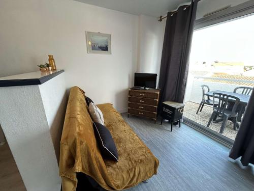 - une chambre avec un lit et une table avec un balcon dans l'établissement Appartement 2 pièces avec balcon, proche plage - FR-1-224B-563, à LʼHerbaudière