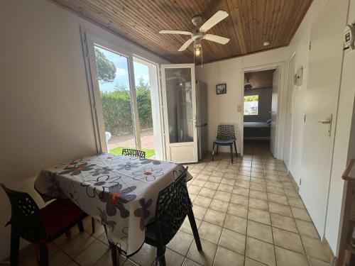 une salle à manger avec une table et des chaises et un ventilateur de plafond dans l'établissement Maison cosy avec cour ensoleillée proche plage - 4 pers - FR-1-224B-502, à La Guérinière