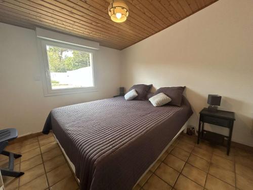 une chambre avec un grand lit avec une fenêtre dans l'établissement Maison cosy avec cour ensoleillée proche plage - 4 pers - FR-1-224B-502, à La Guérinière