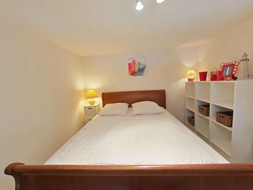 - une petite chambre avec un lit et des étagères dans l'établissement Studio avec Mezzanine, Balcon et Garage à 200m de la Plage – 4 Couchages - FR-1-224-247, à Saint-Hilaire-de-Riez