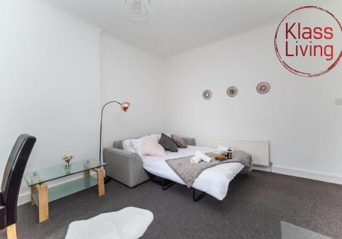 a bedroom with a bed and a couch and a table at Albion Apartment by Klass Living Coatbridge in Coatbridge
