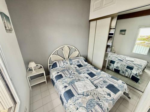 une chambre avec un lit et un miroir dans l'établissement Appartement proche plage Richelieu avec piscine, clim et parking - FR-1-723-14, au Cap d'Agde