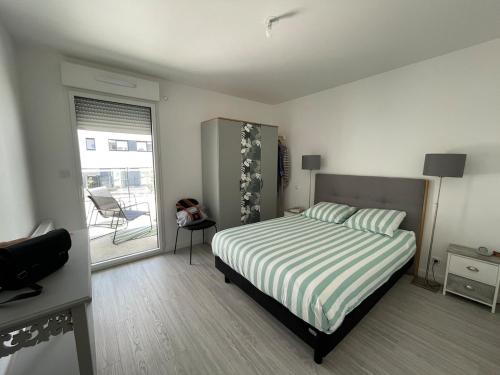 une chambre avec un lit et une porte coulissante en verre dans l'établissement T2 - terrasse - parking - linge inclu, à Vannes