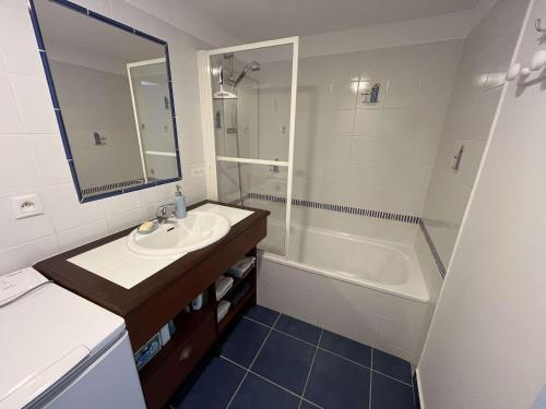 une salle de bain avec un lavabo, une baignoire et un miroir dans l'établissement Maison Avec Terrasse, Piscine, Proche Plage et Forêt à Saint-Hilaire-de-Riez ! - FR-1-324A-63, à Saint-Hilaire-de-Riez