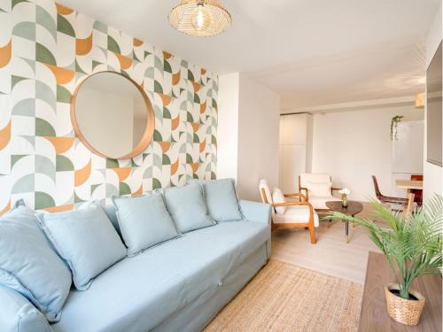 un salon avec un canapé bleu et un miroir dans l'établissement Merveil - Family Suite - Tour Eiffel - Viala I, à Paris