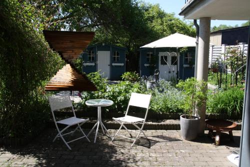 two chairs and a table in a garden at Ferienwohnung An den Linden in Kelmis