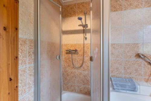 a shower with a glass door next to a tub at Fewo unterm Dreifaltigkeitsberg in Balgheim