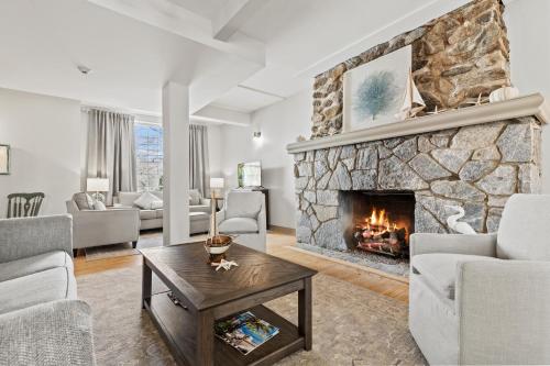 a living room with a large stone fireplace at The Captain Stannard in Westbrook