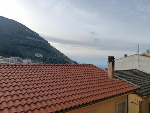 a view of the roofs of two buildings and a mountain at La casa dell'arco in Roccasecca dei Volsci
