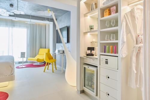a dressing room with a yellow chair and a dressing table at Five Flowers Hotel Formentera, member of Melia Collection in Es Pujols