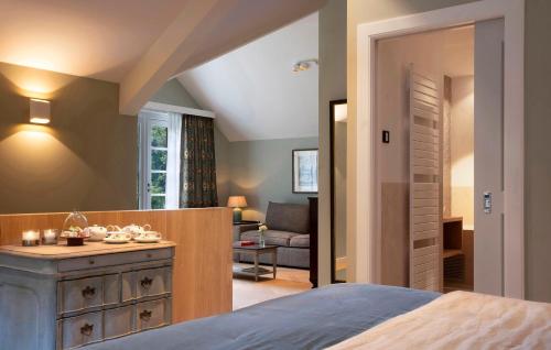 a bedroom with a bed and a living room at Relais & Chateaux Hotel Landgoed Het Roode Koper in Ermelo