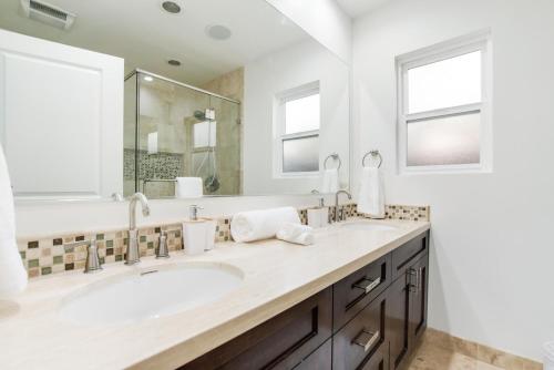 a bathroom with two sinks and a large mirror at Walk to Ventura Boulevard Pool & HotTub with PingPong & BBQ in Sherman Oaks
