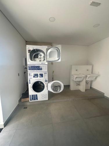 a laundry room with a washing machine and a toilet at APTO TESLA Novo,com Piscina e Ar condicionado in São Carlos