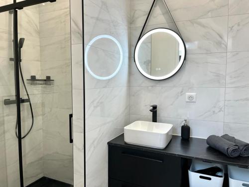 a bathroom with a sink and two mirrors on the wall at Le 5, loc studio malouin in Saint Malo