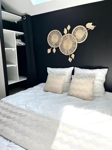 - une chambre avec un lit blanc et un mur noir dans l'établissement Le 5, loc studio malouin, à Saint-Malo