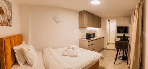 a small bedroom with a bed and a kitchen at Castellum Apartments in Slavonski Brod