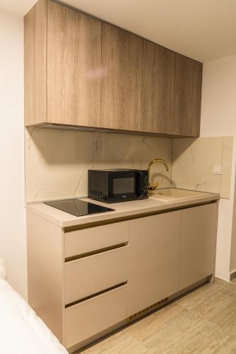 a small kitchen with a microwave on a counter at Castellum Apartments in Slavonski Brod