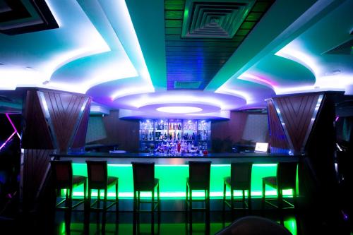 a bar in a nightclub with neon lights at Hotel 71 in Dhaka
