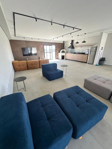 a large living room with blue couches and a couch at APTO TESLA Novo,com Piscina e Ar condicionado in São Carlos