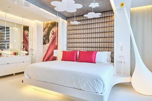 a bedroom with a white bed with red pillows at Five Flowers Hotel Formentera, member of Melia Collection in Es Pujols