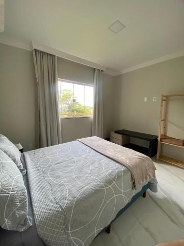 a bedroom with a large bed and a window at Chácara Vista da Mata in Marechal Floriano