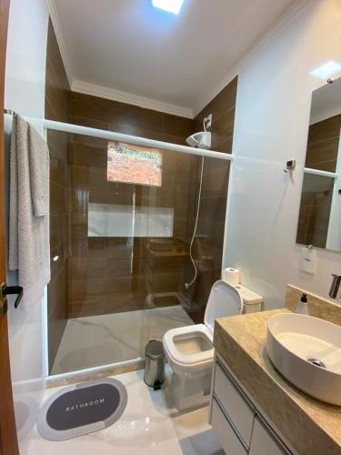 a bathroom with a shower and a toilet and a sink at Chácara Vista da Mata in Marechal Floriano