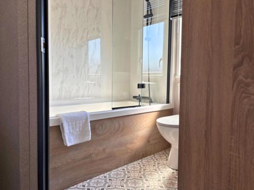 a bathroom with a toilet and a window at Linwater Caravan Park - Luxury Lodges and Static Caravans near Edinburgh in Newbridge