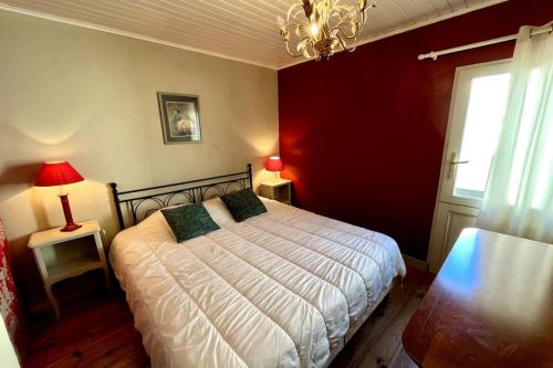 une chambre avec un lit et un mur rouge dans l'établissement The Little Terrace, à Saint-Martin-de-Ré