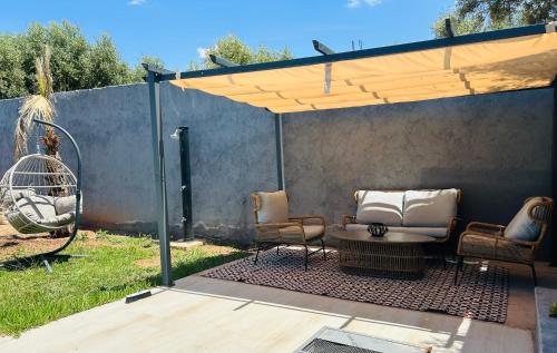 a patio with two chairs and a table and a fence at Villa Naouma in Marrakech