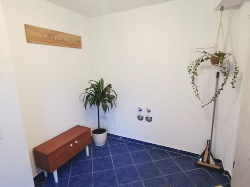 a room with a bench and a plant on a tile floor at Zentrale Erdgeschosswohnung in Sankt Ingbert