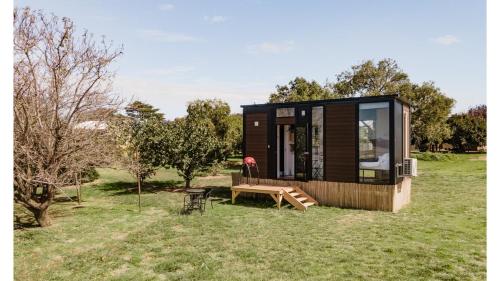 a tiny house sitting on top of a field at Tiny Balloon House by Tiny Away in Canowindra