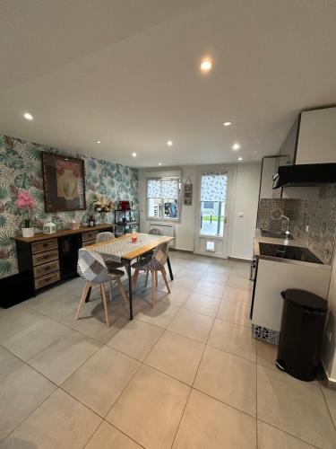 une cuisine avec une table et des chaises dans une pièce dans l'établissement Logement chez l'habitant, à Morangis