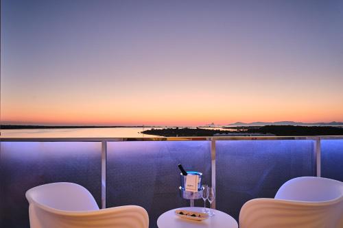 a balcony with a table and chairs at sunset at Five Flowers Hotel Formentera, member of Melia Collection in Es Pujols