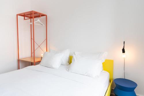 a bedroom with a white bed with white pillows at SATURdAYS in Lisbon