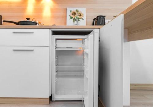 an open refrigerator in a kitchen with a counter at Отель у Ботанического Сада, в самом центре in Astana