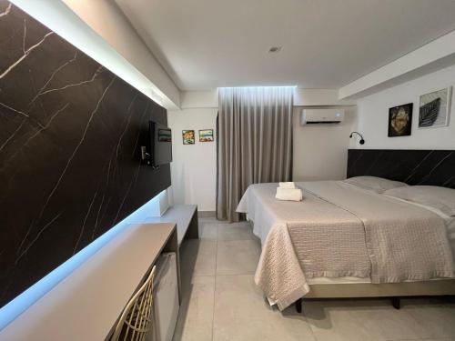 pokój hotelowy z łóżkiem i telewizorem w obiekcie Conforto ao Mar de Manaira Arpoar w mieście João Pessoa