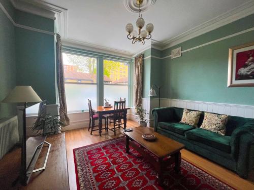 a living room with a green couch and a table at Luxury 1 Bedroom Apartment in Southend w Parking in Southend-on-Sea