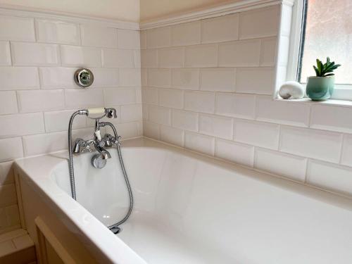 a white bath tub with a shower in a bathroom at Luxury 1 Bedroom Apartment in Southend w Parking in Southend-on-Sea
