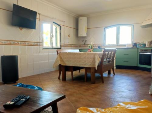a kitchen with a table and chairs in a room at Luar dos Magos in Salvaterra de Magos