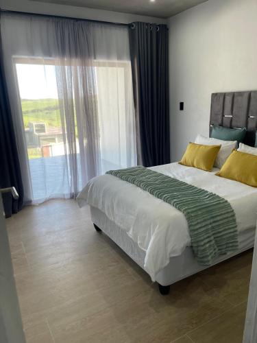 a bedroom with a large bed and a large window at Coastal bliss at YnS apartment! in La Mercy