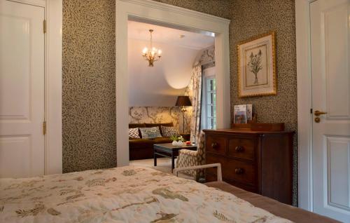 a bedroom with a bed and a desk and a mirror at Relais & Chateaux Hotel Landgoed Het Roode Koper in Ermelo