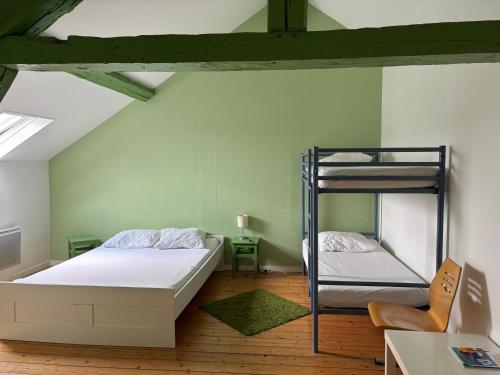 une chambre avec deux lits superposés et un bureau dans l'établissement Hebergements Insolites - Etretat Aventure, aux Loges
