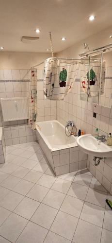 een witte badkamer met een bad en een wastafel bij Ferienwohnung Roko in Eisenach