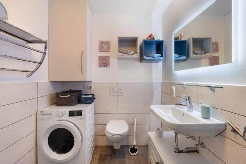 a bathroom with a washing machine and a sink at Wohlfühlhaus in Freiamt