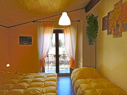 a room with four beds in a room with a window at Agriturismo In Valle Sul Fiume in Calasca Castiglione